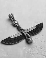 Sterling silver Egyptian Isis pendant with oxidized, detailed wings, shown on a light grey textured surface.