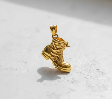 Gold vermeil over silver combat boot pendant showing detailed laces and rugged sole design on white background