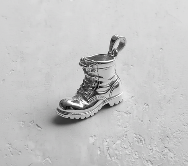 Highly polished 925 sterling silver combat boot pendant with a reflective finish, showcasing its clean lines and shape.