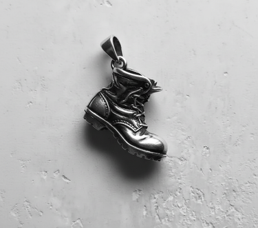 Side profile of silver boot charm highlighting oxidized finish and realistic stitching details for bikers