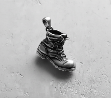 Top angle view of sterling silver combat boot pendant featuring polished toe and sturdy bail for chains