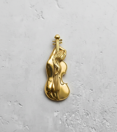 Gold-plated version of the sterling silver violin nude pendant, showcasing its warm, polished finish on a white surface.