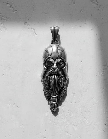 Silver Odin Pendant with an oxidized finish, showing the detailed warrior helmet and braided beard on a white wall.