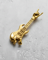 Gold vermeil rock guitar pendant featuring a skull body and 'rock on' hand gesture, shown on a textured light gray surface.