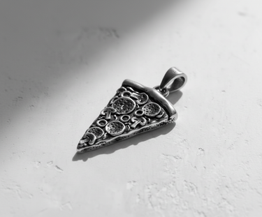 Angled shot of the handcrafted Silver Pizza Pendant, highlighting the 3D relief of the crust and toppings.