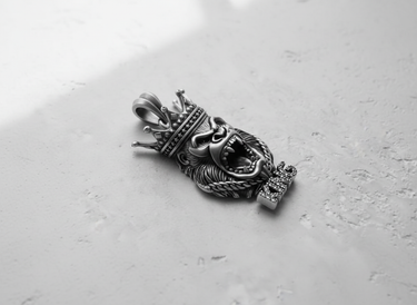 Handcrafted Silver Gorilla Pendant showing the oxidized finish and intricate fur texture, angled on a concrete surface.