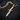 Face Dagger Pendant, gold vermeil, angled view on charred wood