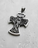 Angled shot of handcrafted silver archangel pendant showing intricate wing and sword relief