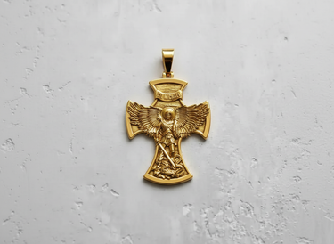Gold vermeil St. Michael pendant featuring archangel slaying a dragon on textured white background