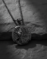 Silver Lion Cross Pendant with ball chain, showcasing the black rhodium plating and detailed relief on a dark slate.
