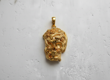 14K gold vermeil skull snake pendant with rose details, shown from the front against a textured white background.