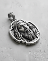 Angled view of the oxidized silver Jesus pendant, showcasing the intricate details of the hair, beard, and ornate bail.