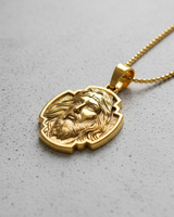 Gold Jesus Christ pendant shown on a ball chain necklace, worn to display its size and how it rests as a piece of faith jewelry.