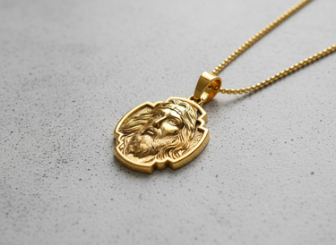 Gold Jesus Christ pendant shown on a ball chain necklace, worn to display its size and how it rests as a piece of faith jewelry.