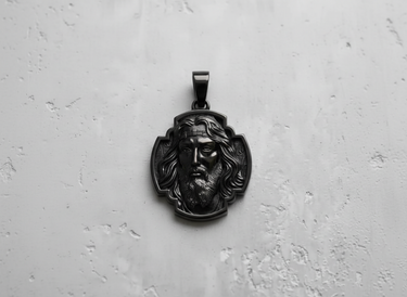 Black rhodium-plated silver Jesus pendant shown from above, highlighting the dark, polished finish on a white background.