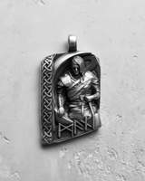 Oxidized sterling silver Viking warrior pendant featuring a relief sculpture and Celtic knot border on a white wall.