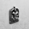 Oxidized sterling silver Viking warrior pendant featuring a relief sculpture and Celtic knot border on a white wall.