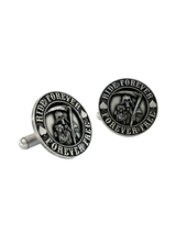An extreme close-up of a Grim Reaper Cufflink, emphasizing the fine details of the scythe, hourglass, and bold lettering.