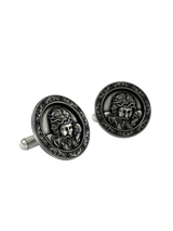 An extreme close-up of a Jesus Christ Cufflink, emphasizing the fine details of the face, hair, and the thorny crown.