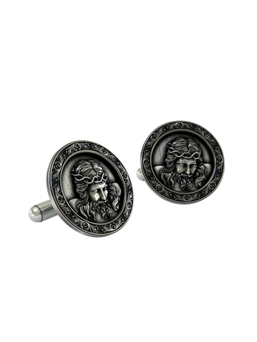 An extreme close-up of a Jesus Christ Cufflink, emphasizing the fine details of the face, hair, and the thorny crown.