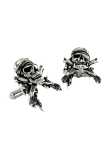 An extreme close-up of a Pirate Skull Cufflink, emphasizing the fine details on the bandana and the engravings on the pistols.