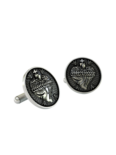 An extreme close-up of a Sacred Heart Cufflink, emphasizing the fine details of the crown of thorns and the emanating divine light.
