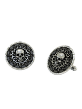 An extreme close-up of a Solar Skull Cufflink, emphasizing the contrast between the smooth skull and the textured, sunburst background.