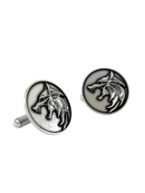 An extreme close-up of a Witcher Wolf Cufflink, highlighting the sharp, stylized details of the wolf's head.