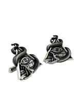 An extreme close-up of an All-Seeing Eye Cufflink, emphasizing the fine details of the snake's scales and the textured pyramid.