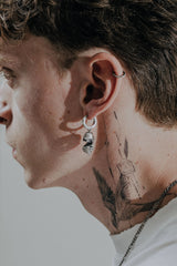 Back view of the Abstract Face Earring's huggie hoop, displaying the "925" hallmark and secure hinged closure.