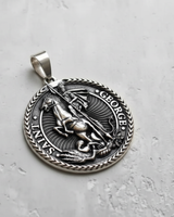 Angled view of the sterling silver Saint George pendant, highlighting the oxidized finish and braided border design.