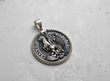 Angled view of the sterling silver Saint George pendant, highlighting the oxidized finish and braided border design.