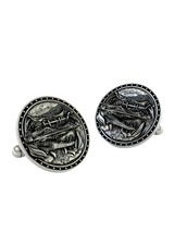 Close-up detail of a single Alligator sterling silver cufflink, focusing on the sharp teeth, detailed scales, and scenic swamp background.