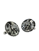 Close-up detail of a single Spartan warrior sterling silver cufflink, focusing on the iconic Corinthian helmet and the intricate cracked-stone background.