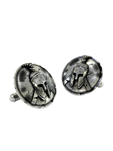 Close-up detail of a single Spartan warrior sterling silver cufflink, focusing on the iconic Corinthian helmet and the intricate cracked-stone background.