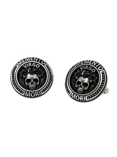 Close-up detail on the Memento Mori Virgo cufflinks, highlighting the intricate engraving on the skull and surrounding text.