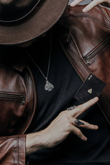 Side angle view of the Sterling Silver Death Gambler Pendant, highlighting the 3D relief of the skull and cards.