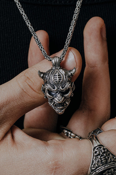 Side angle view of the Sterling Silver Oni Mask Pendant, highlighting the sharp horns and 3D details.
