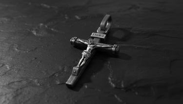 Side profile view of INRI Crucifix Pendant sterling silver cross displaying dimensional relief and corpus detail