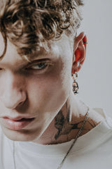 The Abstract Face Earring shown worn on an ear to demonstrate its actual size and artistic impact.