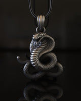 925 sterling silver cobra pendant with detailed scales and raised hood on black reflective surface background