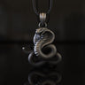 925 sterling silver cobra pendant with detailed scales and raised hood on black reflective surface background