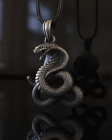 Close-up of silver cobra pendant displaying intricate scale texture and fierce serpent head craftsmanship