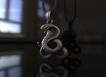 Close-up of silver cobra pendant displaying intricate scale texture and fierce serpent head craftsmanship