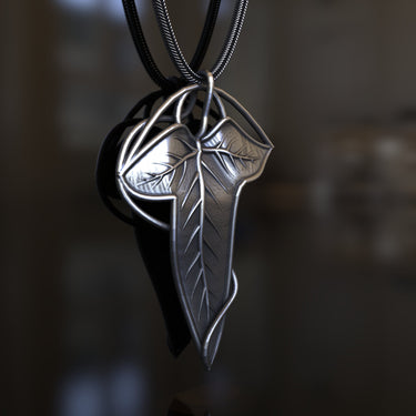 Side profile of the sterling silver leaf pendant, showcasing the elegant wireframe and bail design against a dark backdrop.