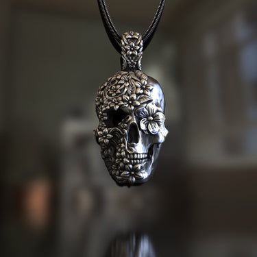 Close-up of sugar skull pendant featuring intricate flower carvings and premium sterling silver finish