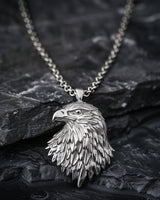 925 sterling silver eagle head pendant with detailed feathers displayed on dark stone background showing craftsmanship