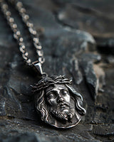 925 sterling silver Jesus Christ pendant with Crown of Thorns detail on weathered stone background showing oxidized finish