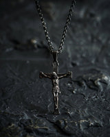 925 sterling silver crucifix pendant with Jesus Christ figure displayed on dark textured stone background