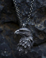 925 sterling silver eagle head pendant with detailed feathers and oxidized finish on dark stone background